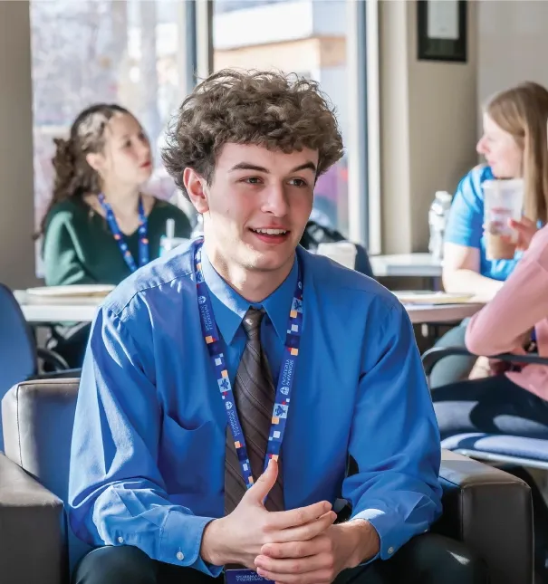 One male student sitting in an admissions event.